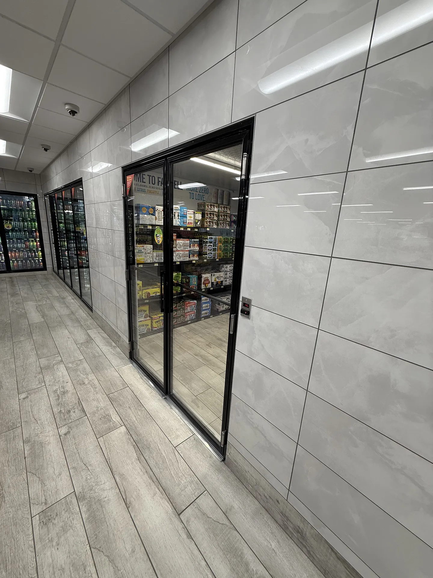 mart_project2 Walk-in cooler entrance with glass sliding doors and tiled exterior wall